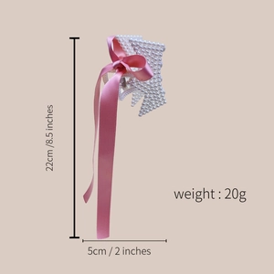 Detailed view of the 22cm long pearl hair claw clip with pink satin ribbon bows