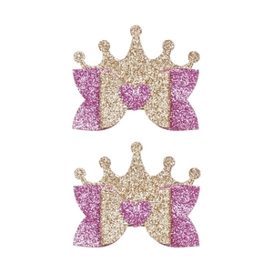 Detailed view of pink glitter crown and bow hair clips for girls with a shiny finish