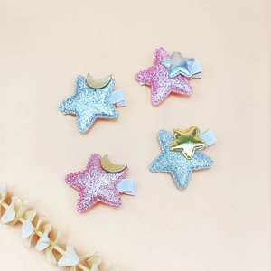 Close-up of glitter star and moon hair clips for girls in pink and blue sparkles