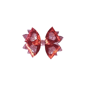 Détail d'un nœud papillon à paillettes rouges avec des motifs de cœurs roses pour fille