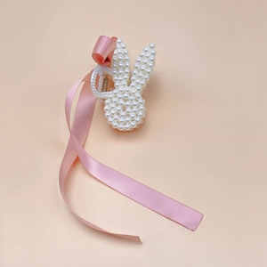 Close-up of pearl rabbit hair claw clip with long pink ribbon for girls