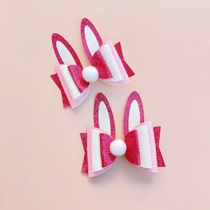 Detail of pink and white sequin rabbit ear hair clips with fuzzy pom-poms for Easter decor