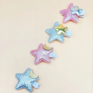 Close-up of glitter star hair clips with small gold and silver moon and star accents