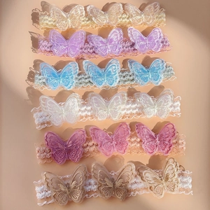 Detail view of set of six elastic lace headbands with embroidered mesh butterflies in varied colors
