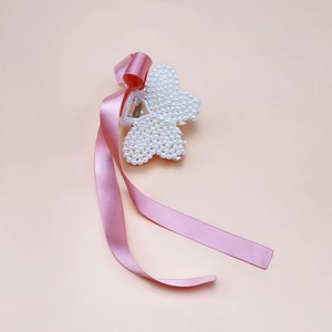 Detail of pink silk ribbon and pearl flower hair claw clip with delicate textures