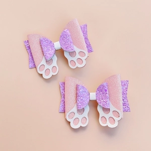 Detail of pink and purple glitter hair bows with cute white cat paw accents
