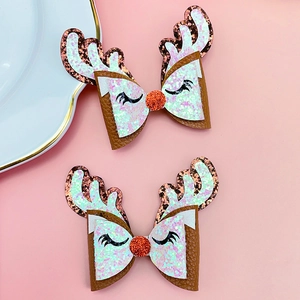 Detail of Christmas reindeer bow hair clips with pink glitter antlers and eyelashes