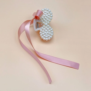 Detailed view of kids pearl bow hair claw with pink silk ribbon and secure metal spring