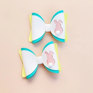 Detail of multi-layered Easter rabbit hair clips with white matte fabric and yellow glitter