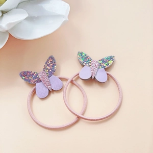 Dettaglio di elastici a farfalla in pelle PU viola con paillettes colorate per bambini
