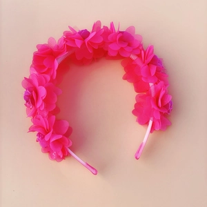 Detailed top view of rose pink mesh flower headband for girls on light apricot background