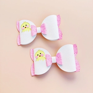 Detail of pink glitter bow hair clips with cute chicken graphics for Easter decor