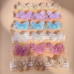 Flat lay of six colorful lace baby headbands with delicate embroidered butterfly details
