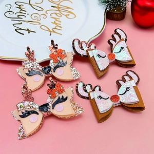 Detail view of four festive Christmas reindeer bow hair clips with glitter fabric texture