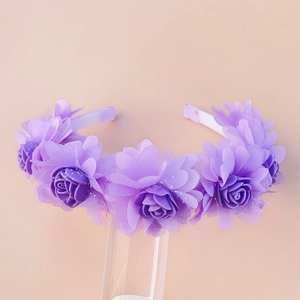 Detailed close-up of purple floral headband with mesh petals on clear acrylic stand