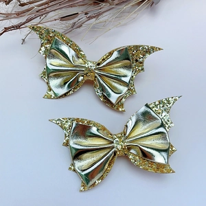 Close-up of golden bat wing hair clips with glitter sequins for Halloween party hair styling