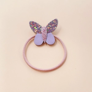 Dettaglio elastico per capelli farfalla con paillettes in ecopelle rosa e viola a strati