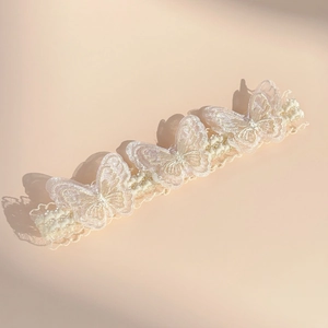 Close-up of lace baby headband with embroidered double-layer butterflies and pearls
