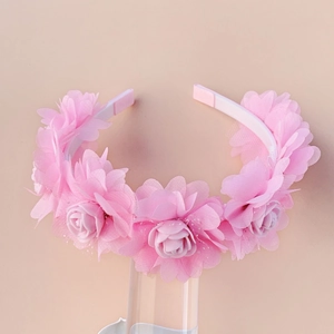 Detail view of handmade pink tulle rose flowers on a children floral headband
