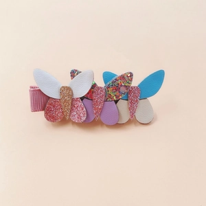 Dettaglio di fermagli per capelli a farfalla in pelle PU multicolore con glitter per bimbi