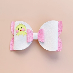 Detail of Easter hair clip with white faux leather bow and cute yellow chick decoration