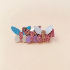 Dettaglio di un fermaglio a farfalla per bambini in ecopelle colorata con paillettes luccicanti