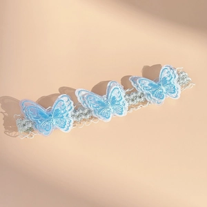 Detailed close-up of light blue butterfly embroidery and lace texture on elastic headband