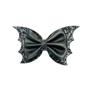 Detail of bat wing hair clip with black faux leather bow and glittery sequins for girls
