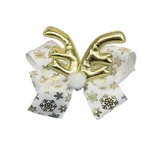 Detail of Christmas bow hair clip with gold snowflake patterns and plush reindeer antlers