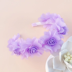 Detailed view of purple floral headband with layered mesh roses on satin base