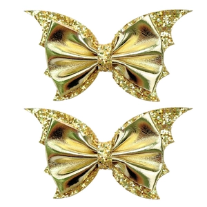 Close-up of golden sequin bat wing hair bows with glittery metallic finish for parties