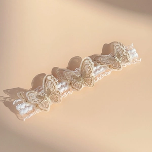 Detail of three-dimensional gold embroidered butterfly lace headband for babies