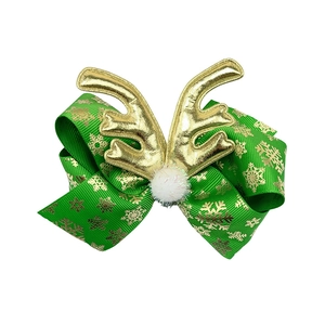 Detail of Christmas hair clip with green snowflake ribbon, golden antlers and white pompom