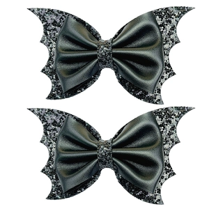 Detail of bat wing bow hair clips with black matte faux leather and silver sequins texture
