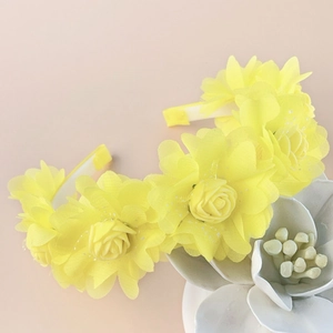 Detail of yellow fabric rose headband showing translucent petals and delicate mesh textures
