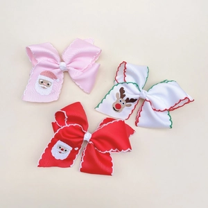 Detailed view of handmade Christmas ribbon hair clips with Santa and reindeer embroidery