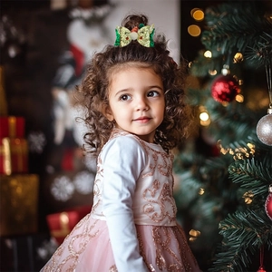 Christmas reindeer hair clip with glitter antlers and white pom-poms on a girl