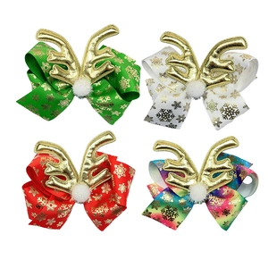 Detail showing 4-pack Christmas bow hair clips with gold reindeer antlers and snowflakes