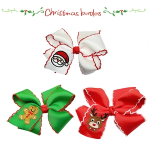 Detail of Christmas bow hair clips with Santa, gingerbread man and reindeer embroidery