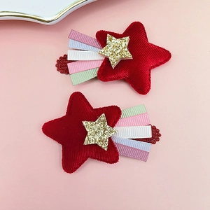 Détail de barrettes étoiles en velours rouge avec glands en ruban coloré pour enfants