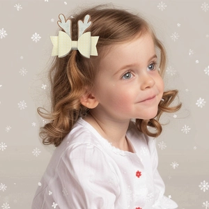 Primer plano de una niña con un lazo para el pelo con astas de reno de Navidad brillante