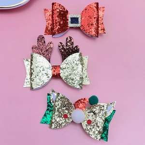 Detailed view of three festive Christmas glitter hair clips with reindeer and Santa designs