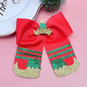 Detailed close-up of Christmas elf bow hair clip with festive red and green glitter details