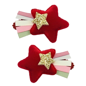 Détail de pinces à cheveux étoile en velours rouge avec étoile dorée et rubans colorés