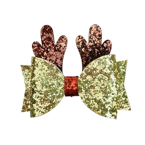 Detail of Christmas reindeer antler hair clip with red and gold glitter bow