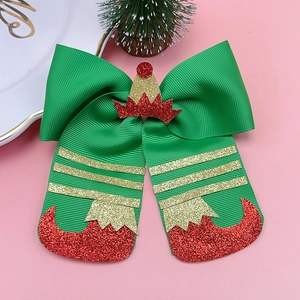 Close-up of green ribbed ribbon Christmas hair bow with glitter elf boots and hat details