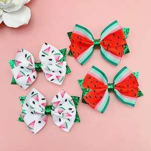 Détail de quatre barrettes nœuds pastèque avec paillettes vertes et motifs de fruits