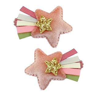 Détail de la pince à cheveux étoile en velours rose avec glands en ruban coloré