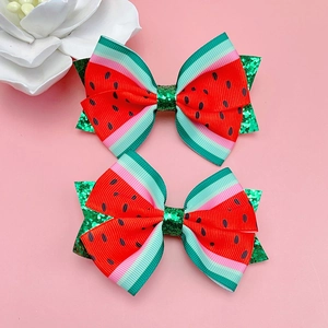 Détail de deux nœuds à cheveux pastèque avec paillettes et imprimés de fruits mignons