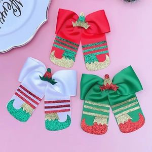 Detailed close-up of glittery elf boot hair bows in festive red and green colors
